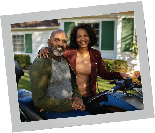 Couple on a motorcycle Black couple on a motorcycle with a house in the background