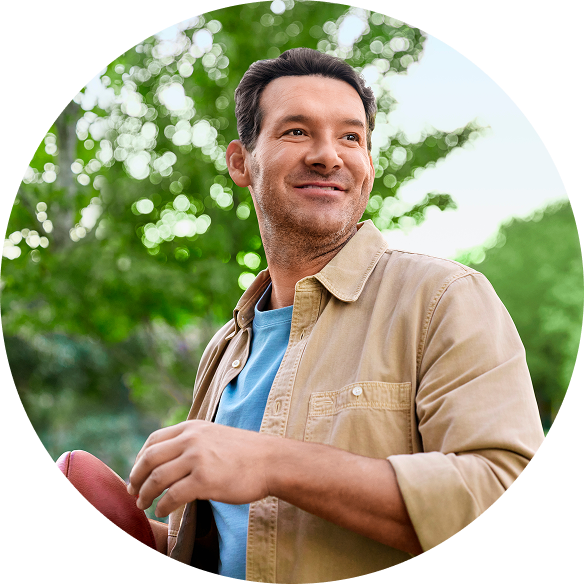 Tony Romo outdoors with a football in hand